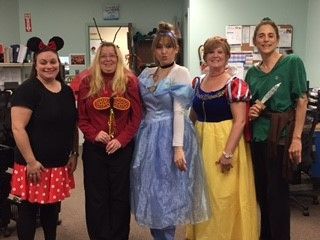 Five people in costumes for Halloween. Minnie Mouse, a butterfly, Cinderella, Snow White, and Peter Pan pose together.