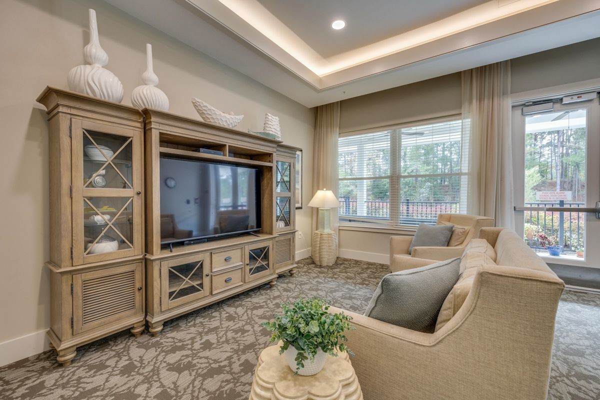A living room with a couch , chair , table and television.