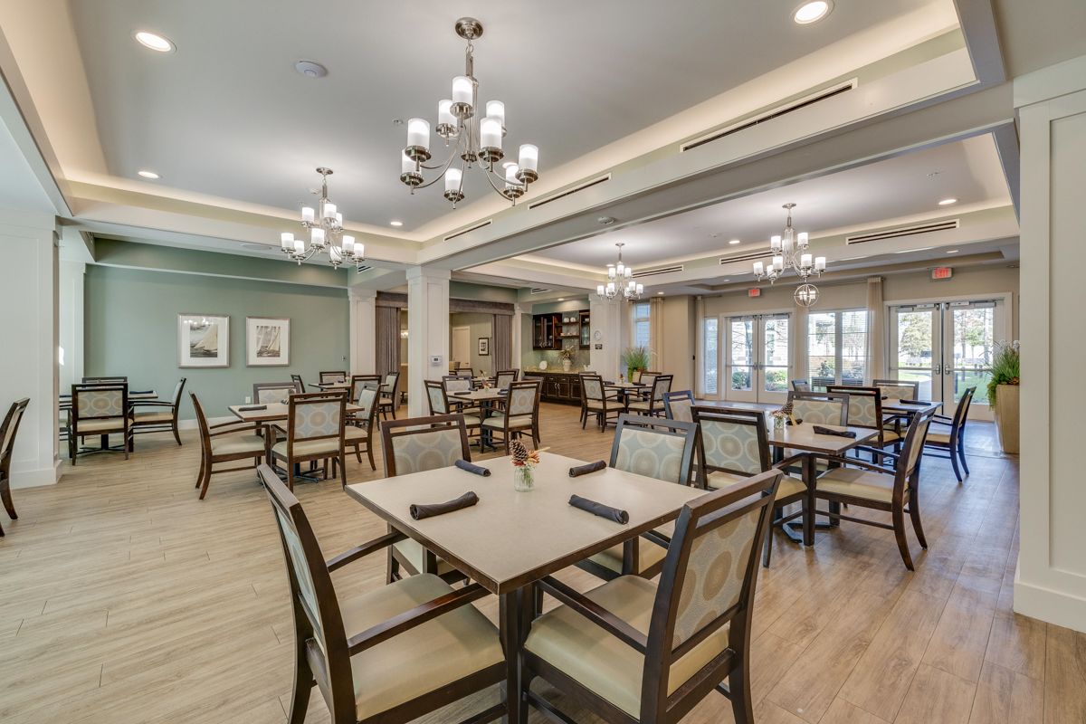 A large dining room with tables and chairs and a chandelier.