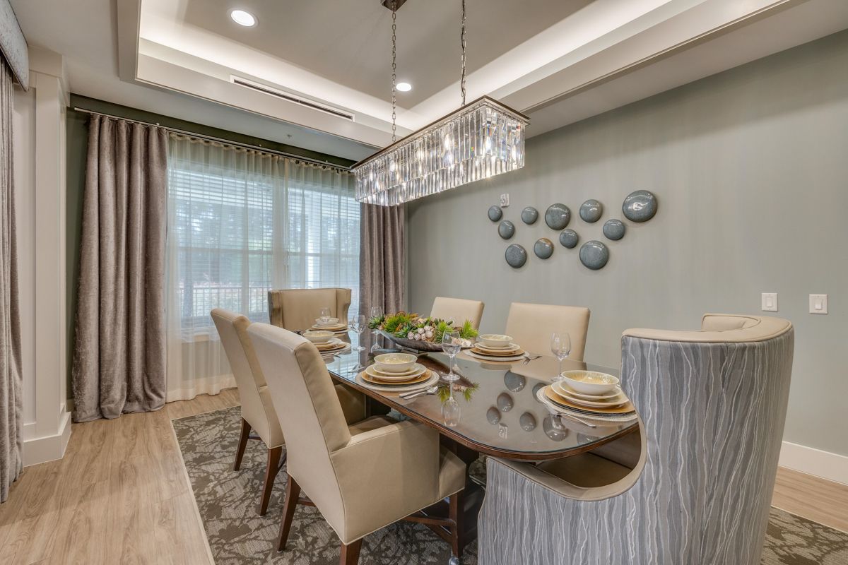 A dining room with a table and chairs and a chandelier.