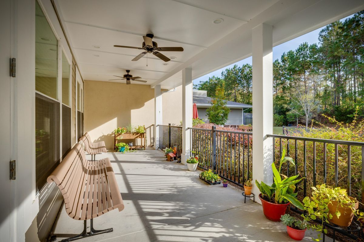 A porch with a bench and a ceiling fan.