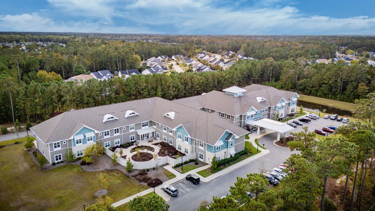 An aerial view of a large apartment building surrounded by trees.