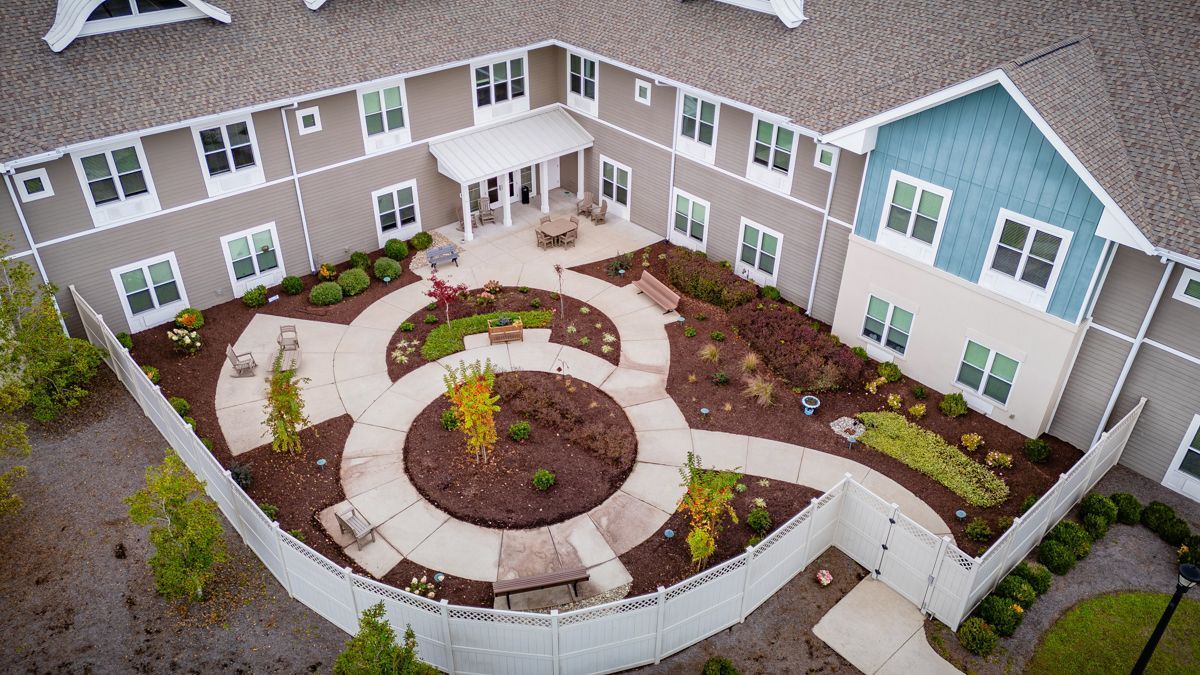 An aerial view of a large house with a garden in front of it.
