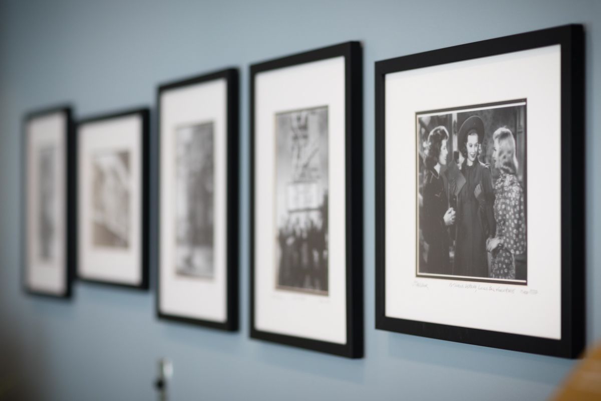 A row of black and white framed pictures on a wall
