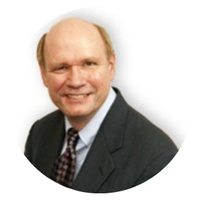 A bald man in a suit and tie smiles for the camera