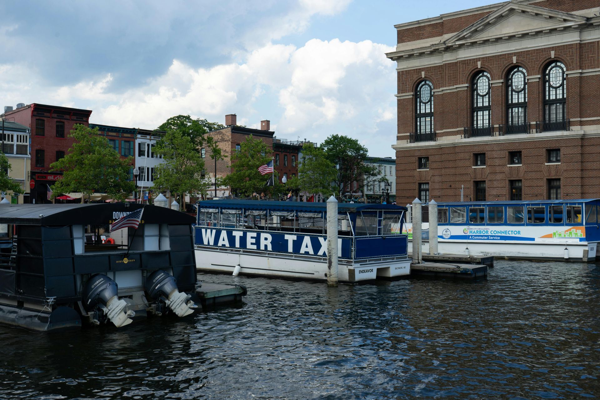 A water taxi is docked in front of a brick building