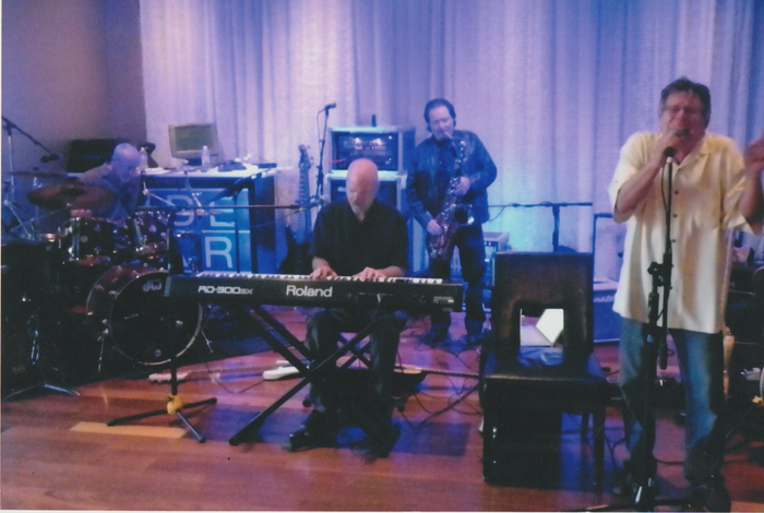 A man is playing a roland keyboard on stage