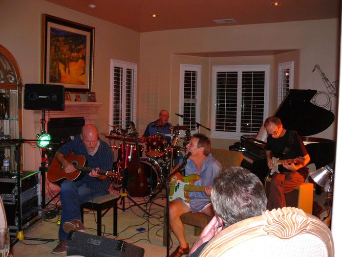 A group of men are playing instruments in a living room