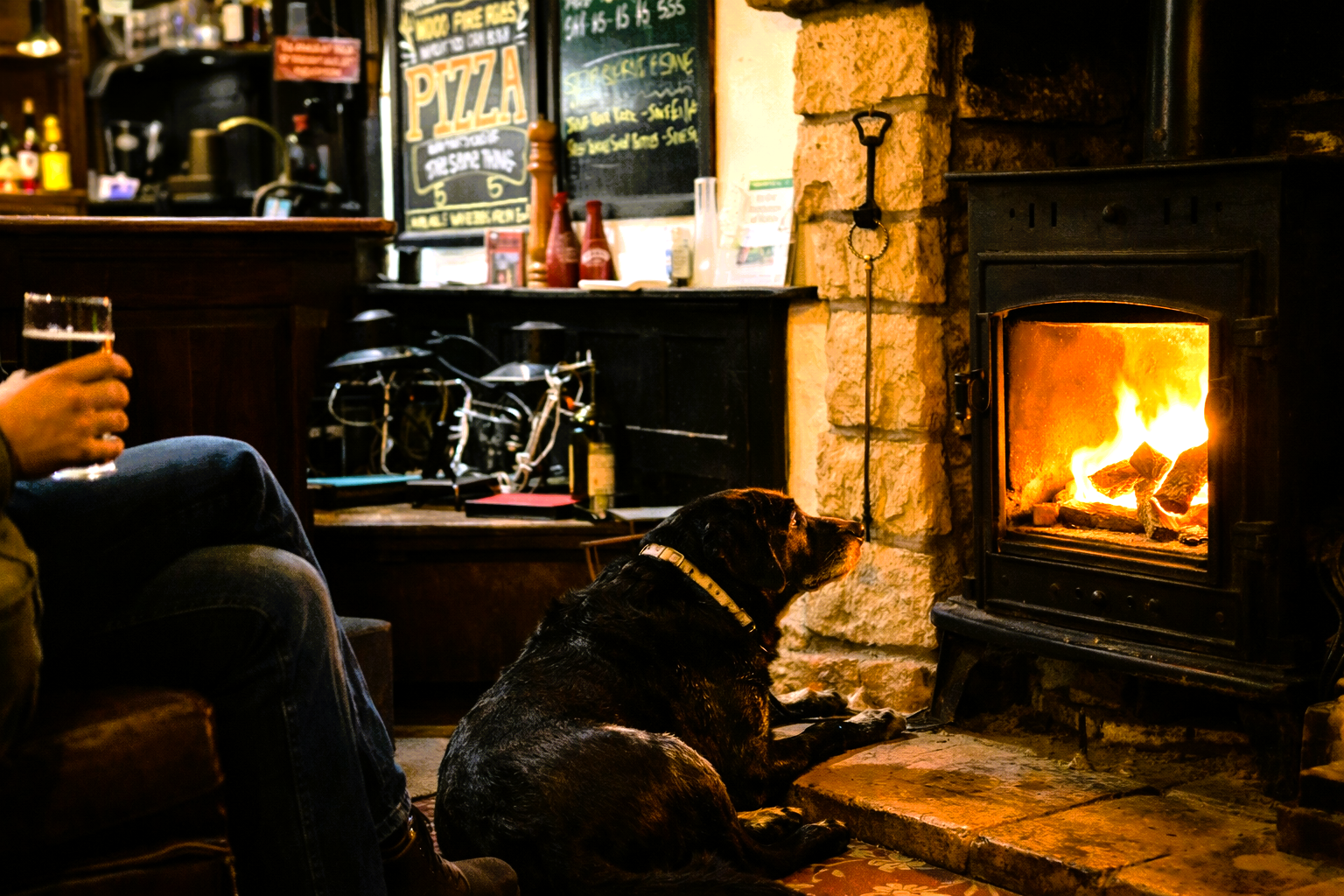 Dog in front of a wood burner at the Three Horseshoes.