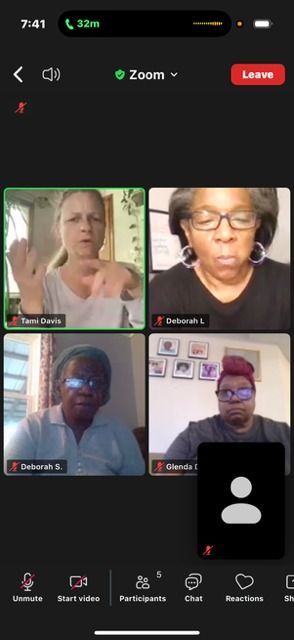 Four people in a Zoom meeting. Three women and one man, all are facing the camera. Zoom interface visible.