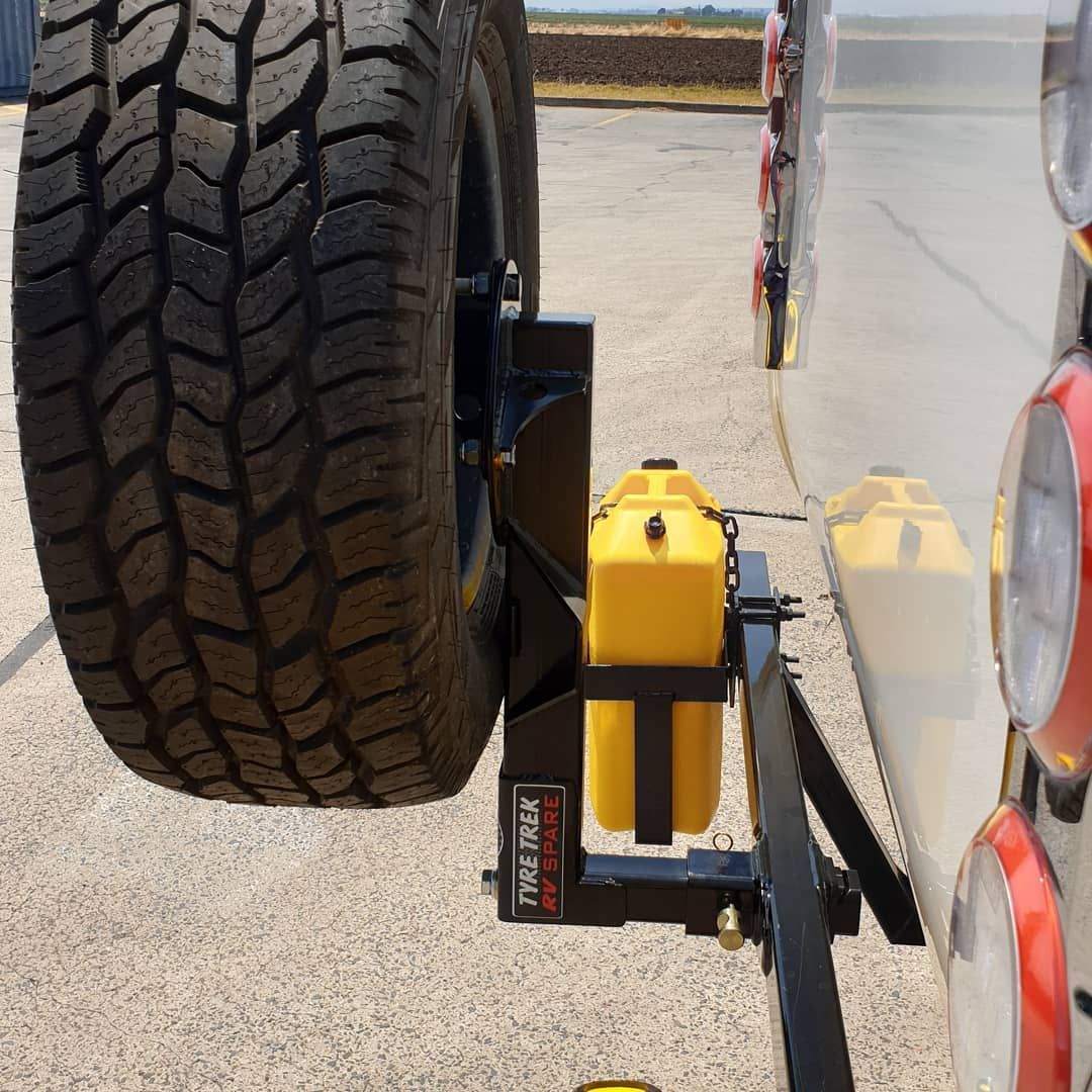 A tyre rack is attached to the back of a vehicle
