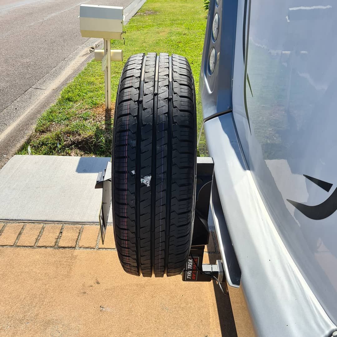 A tyre is attached to the back of a rv