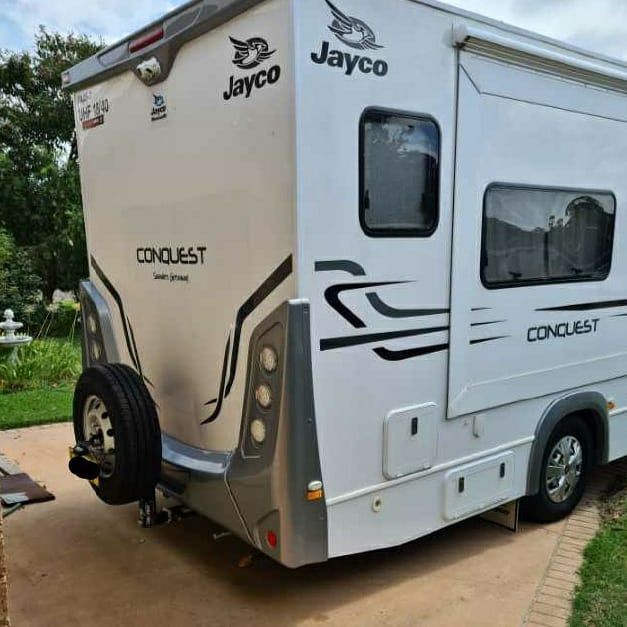 A white jayco conquest rv is parked in a driveway