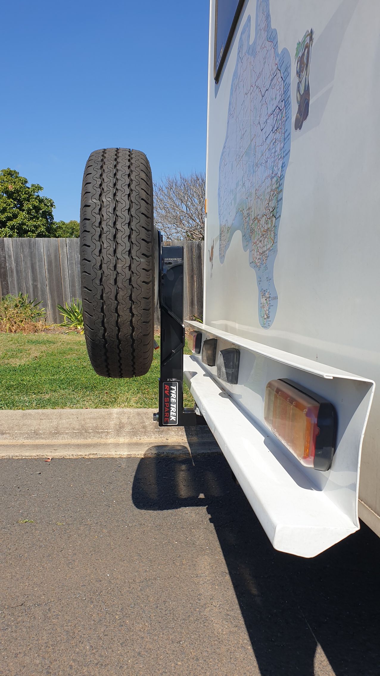 A white van with a spare tyre attached to the back of it.