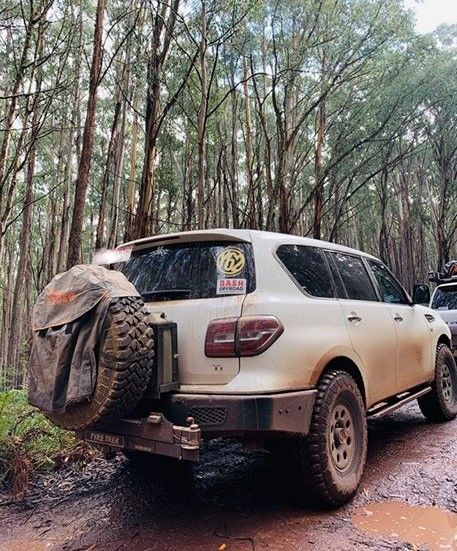 A white suv is parked on a muddy road in australia.