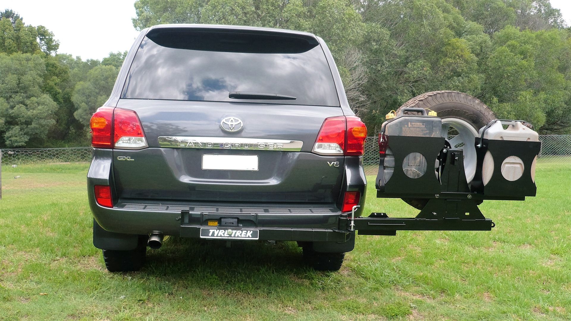 A toyota land cruiser is parked in a grassy field.