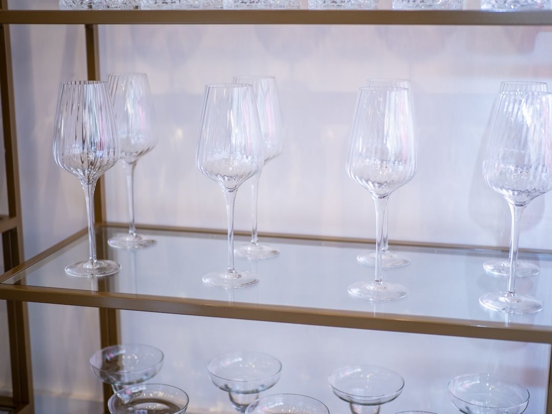 Textured wine glasses on a gold shelf