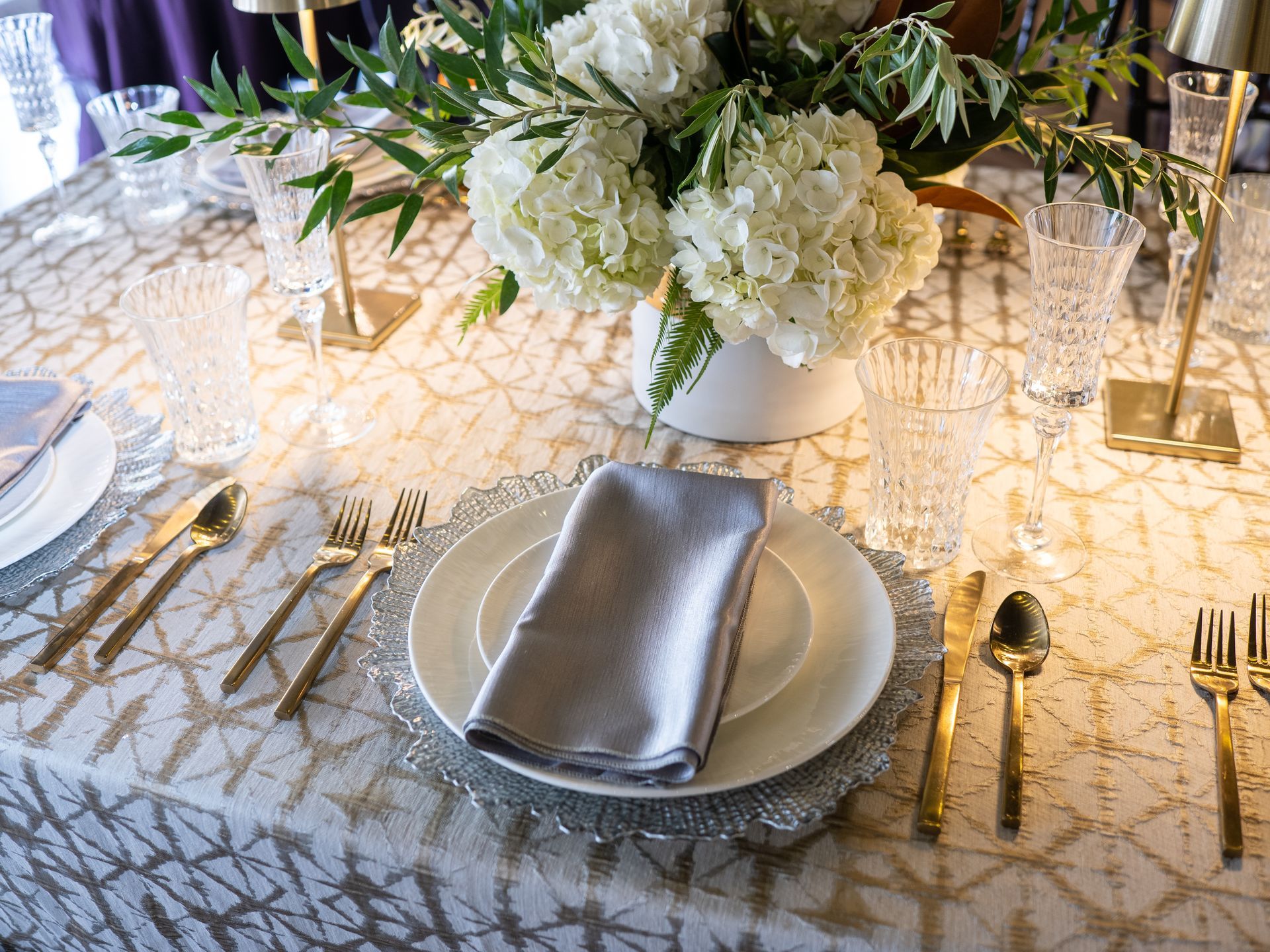 champagne metallic table with gold flatware and cut crystal 