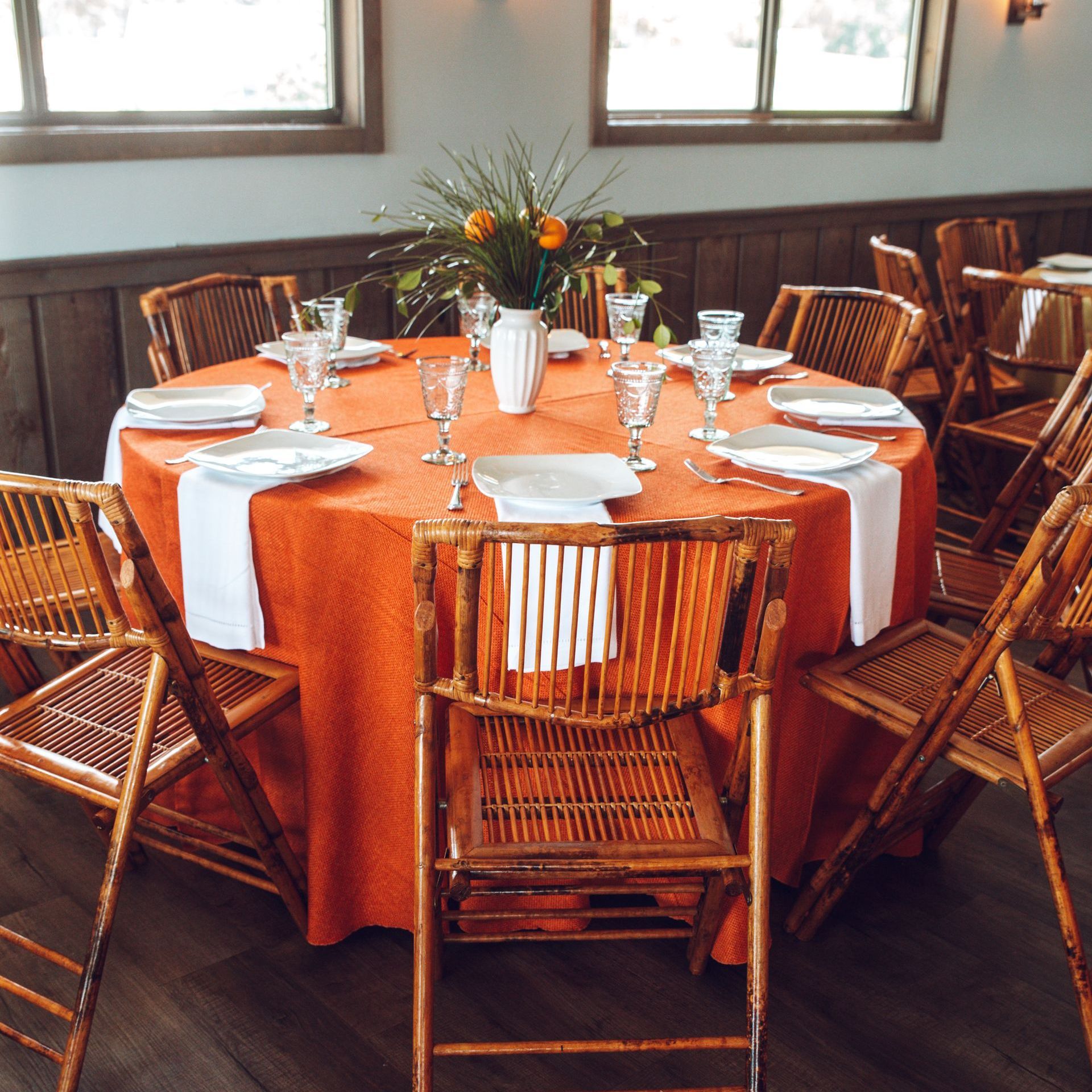 orange table with bamboo chairs and fruit accents