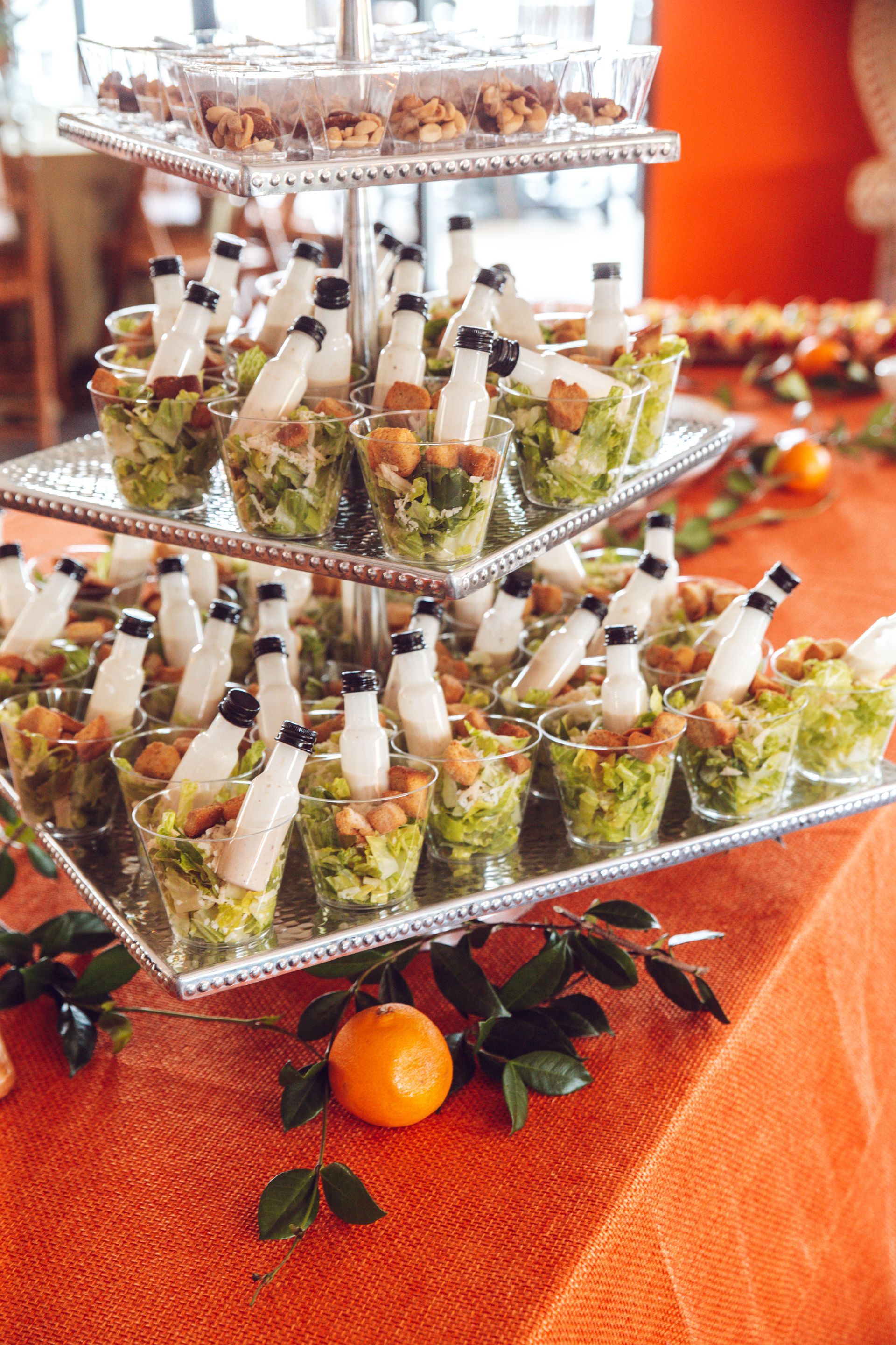 3-tier stand on orange table with mini salads