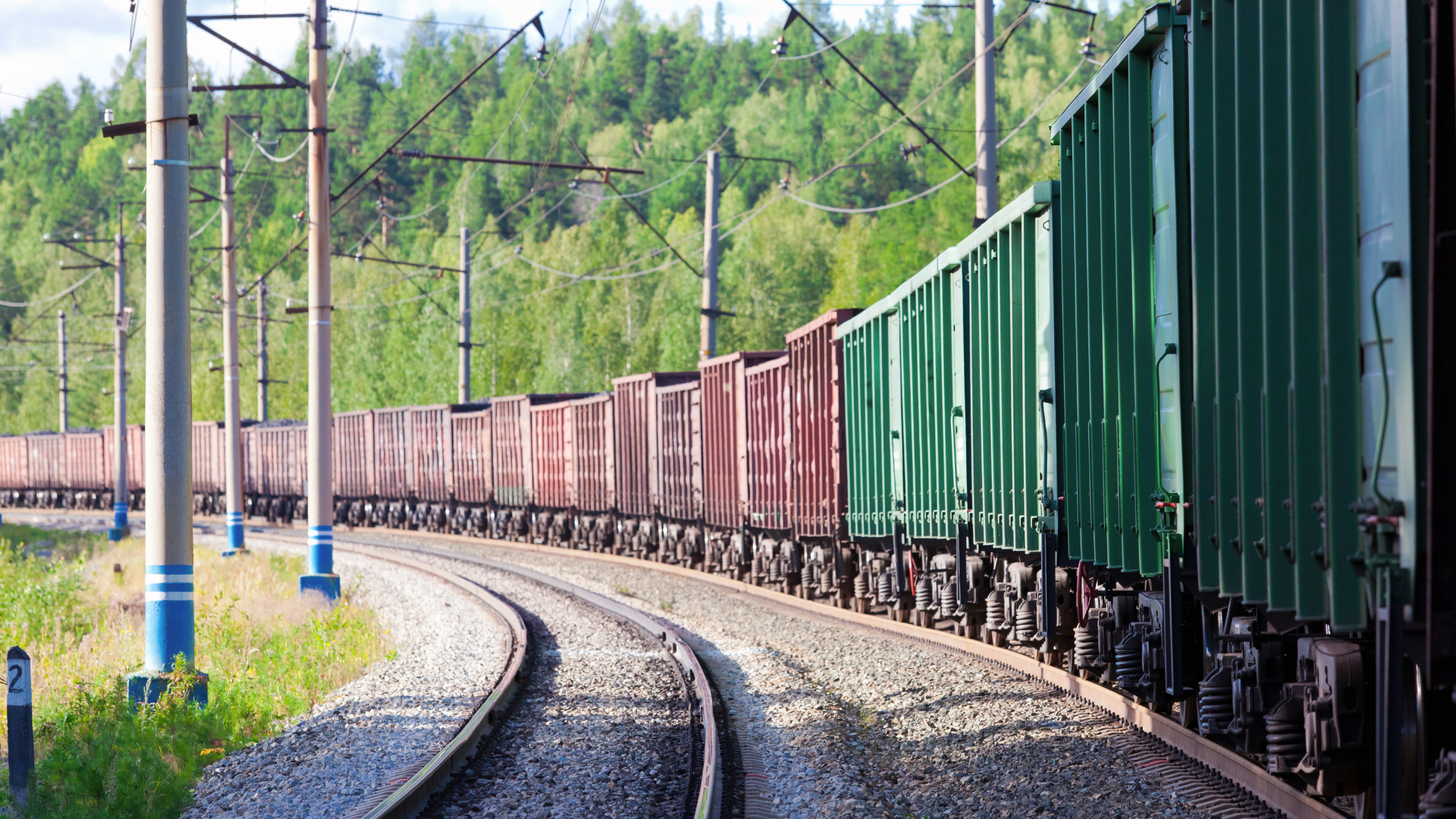 A train is going down the tracks in the countryside.