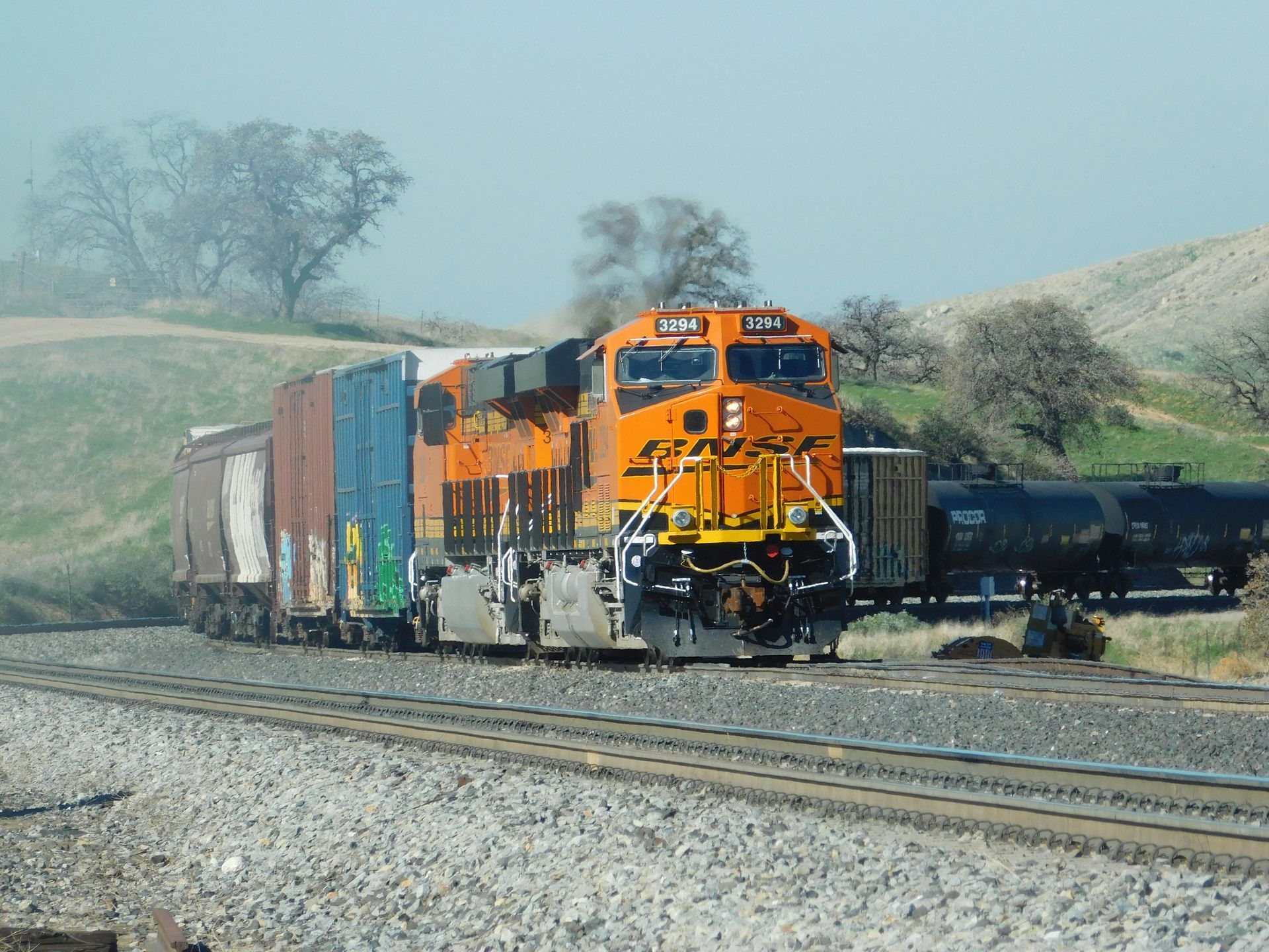 A train is going down the tracks on a sunny day