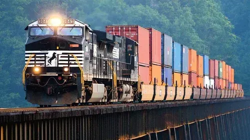 A train with containers on it is going over a bridge.