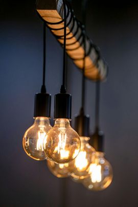 Row of glowing Edison bulbs hanging against a dark wall