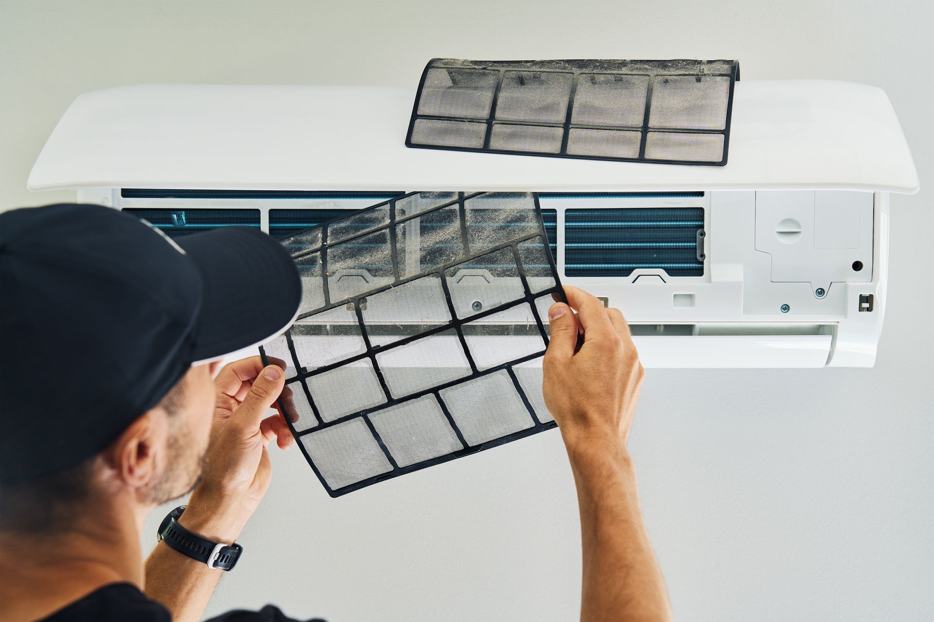 Person cleaning air conditioner filter.