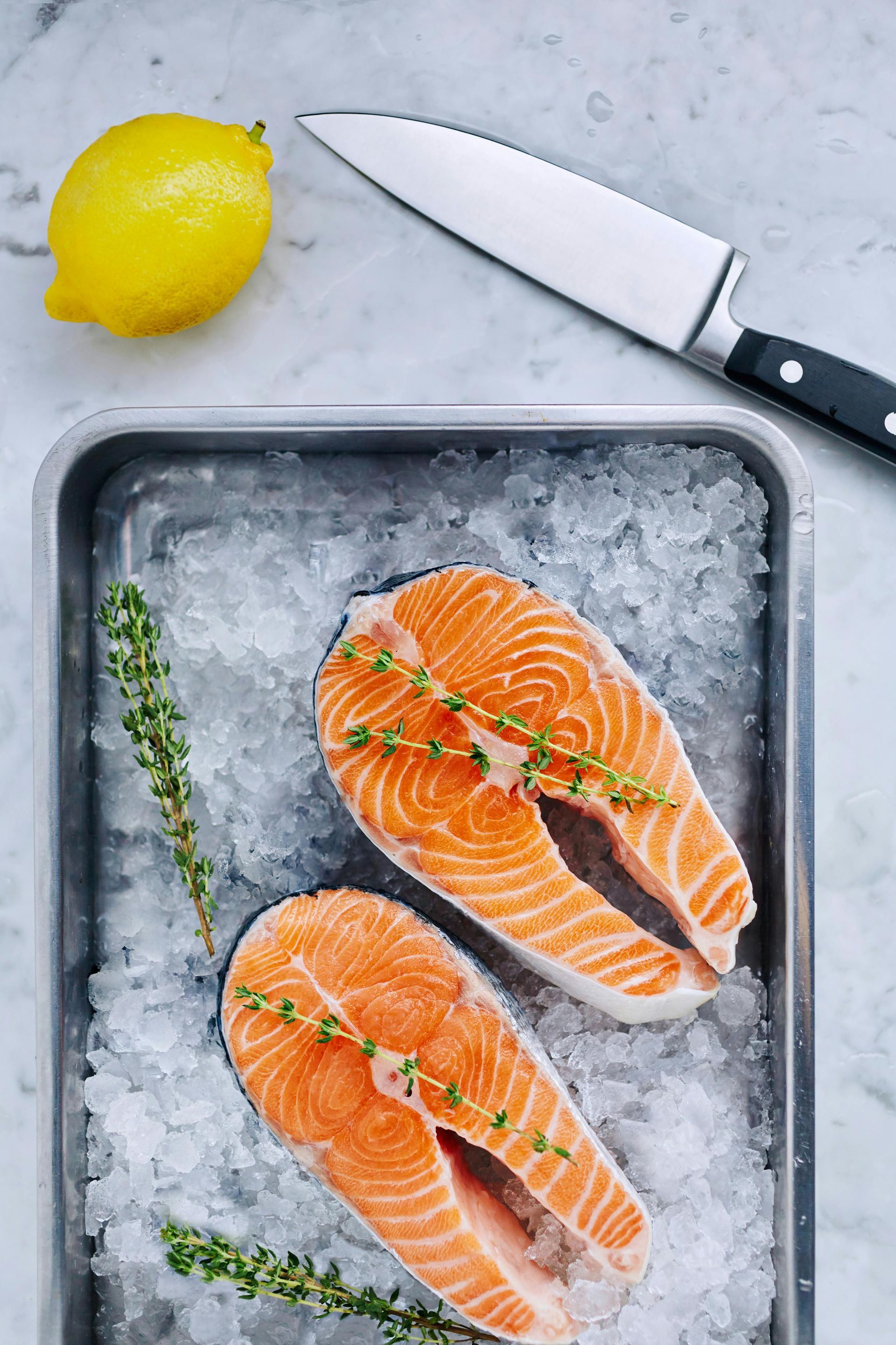 Newborn baby sleeping on a blue blanket, wearing gray suspenders.