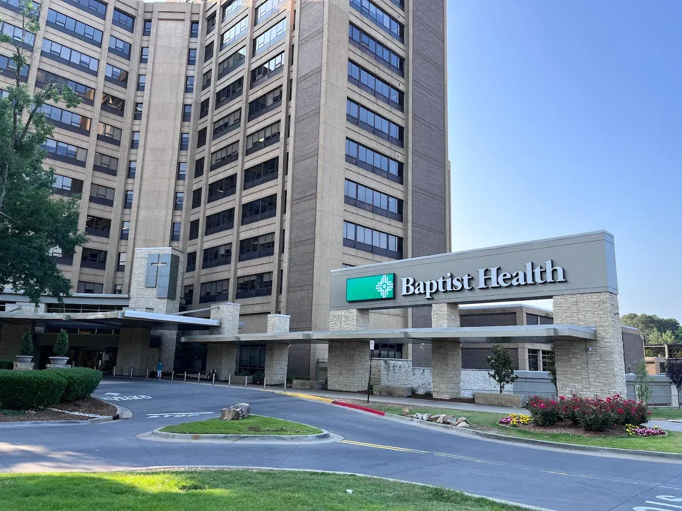 Baptist Health hospital building with a sign in front. Brown stone structure.