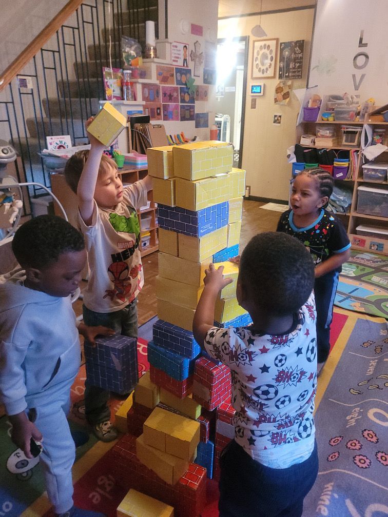 Children gather around a white table, drawing and creating colorful crafts with paper, markers, and scissors.