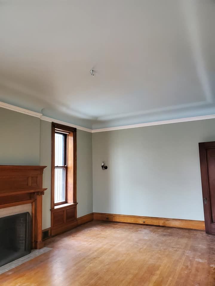 An empty living room with a fireplace and a window.