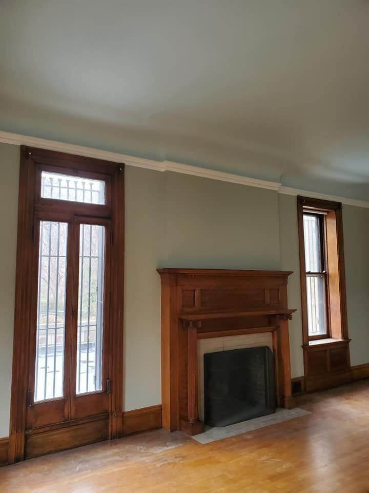 An empty living room with a fireplace and windows