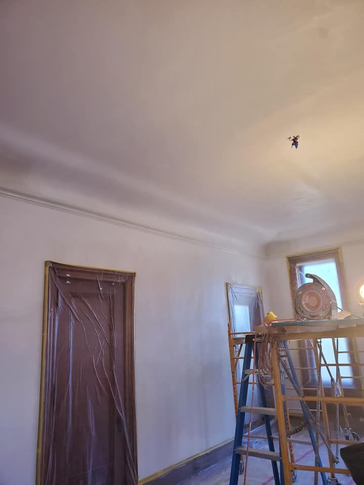 A ladder is sitting in a room next to a door.