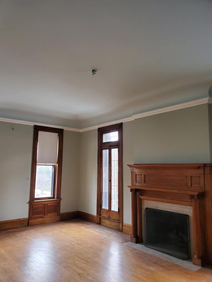 An empty living room with a fireplace and windows