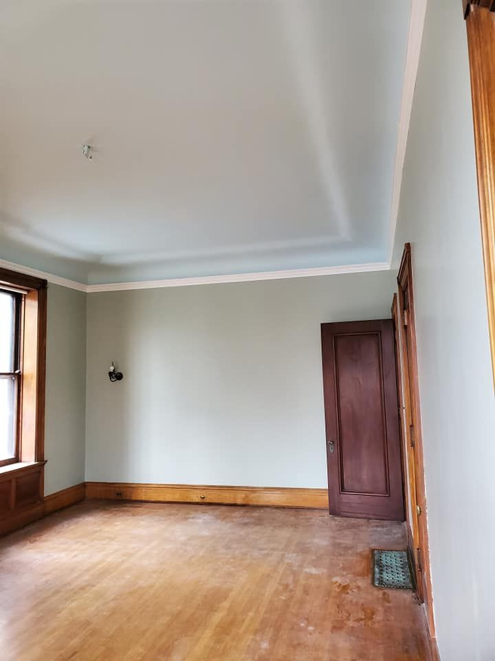 An empty living room with hardwood floors and a window.