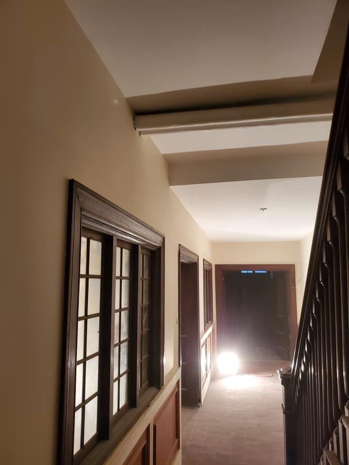 A hallway with a staircase and a few windows