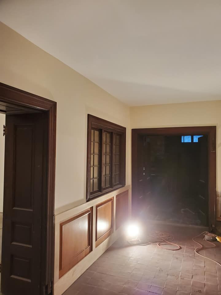 A room with a lot of windows and a light on the floor