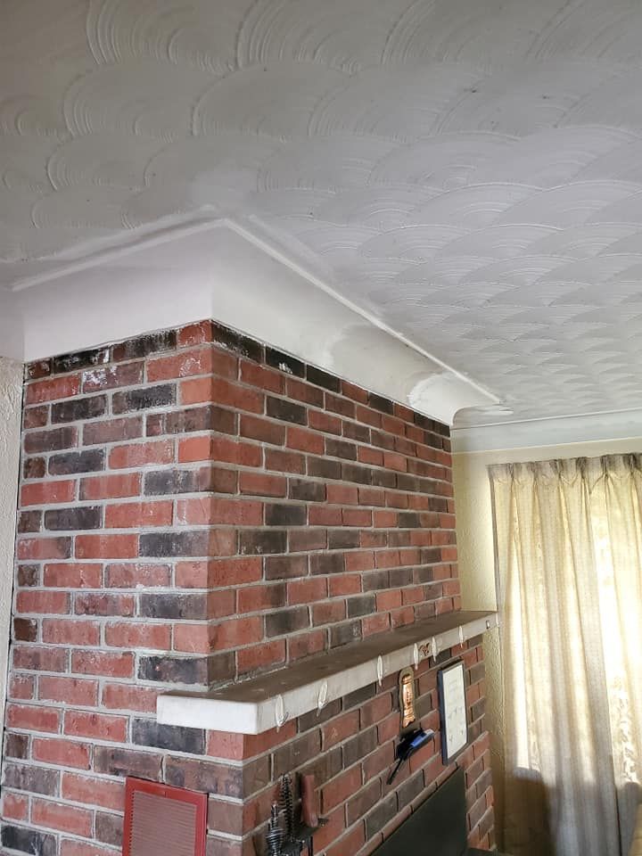 A living room with a fireplace and a brick wall.