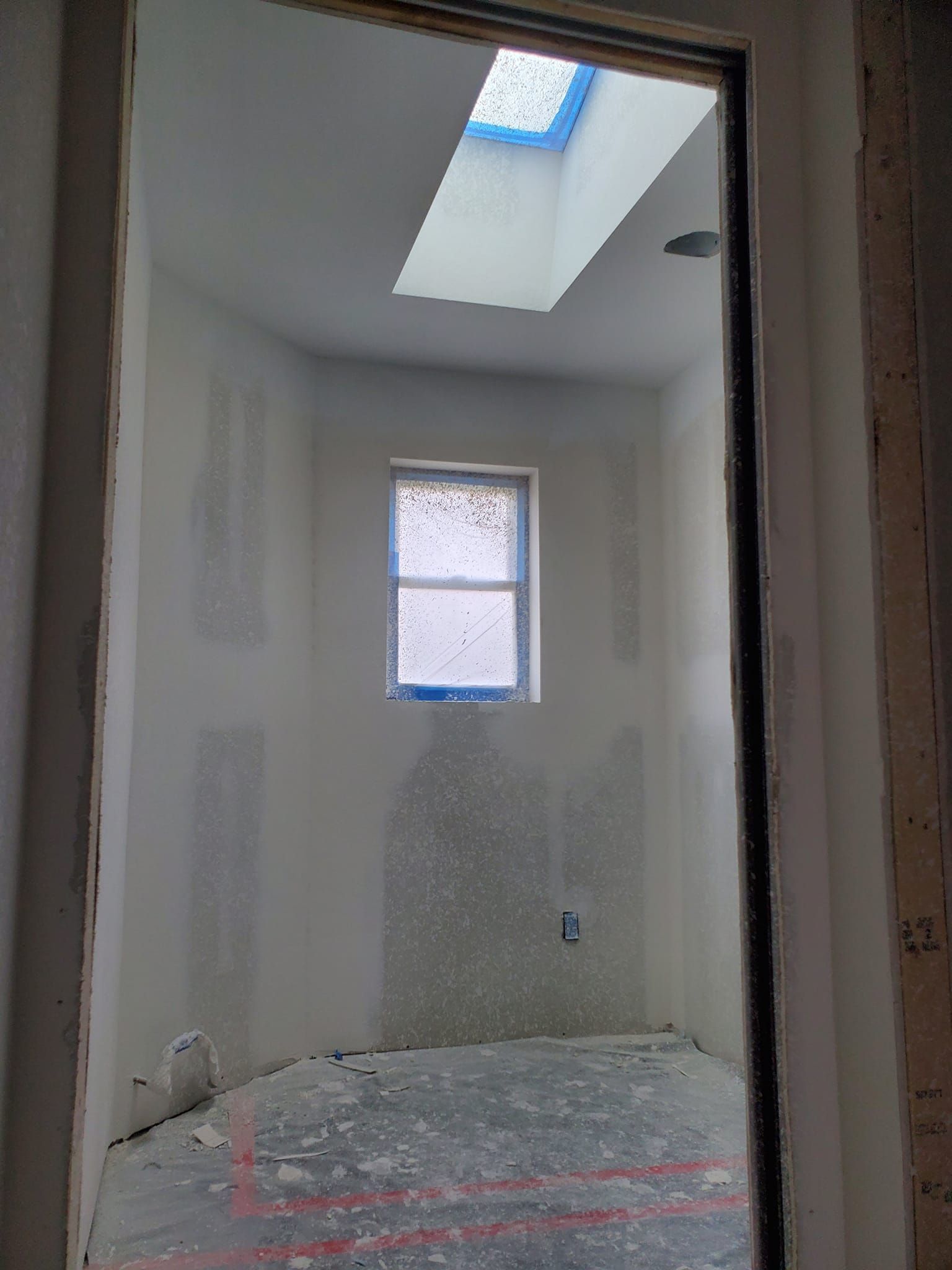 A room with a window and a skylight in the ceiling.