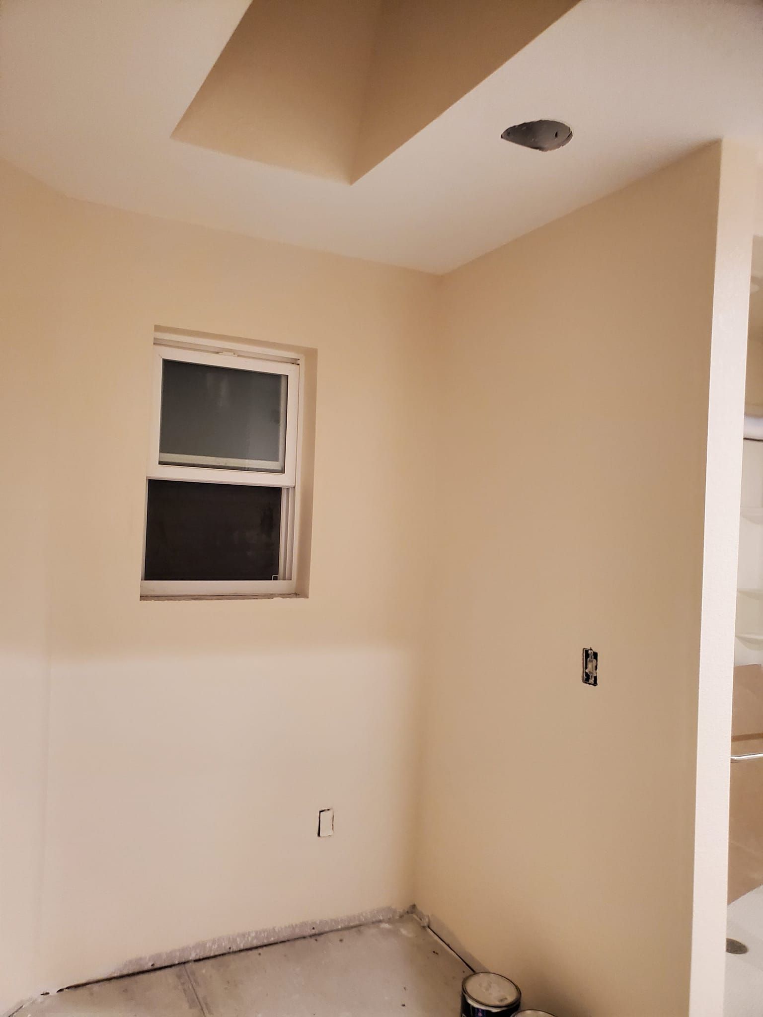 An empty room with a window and the letter r on the wall