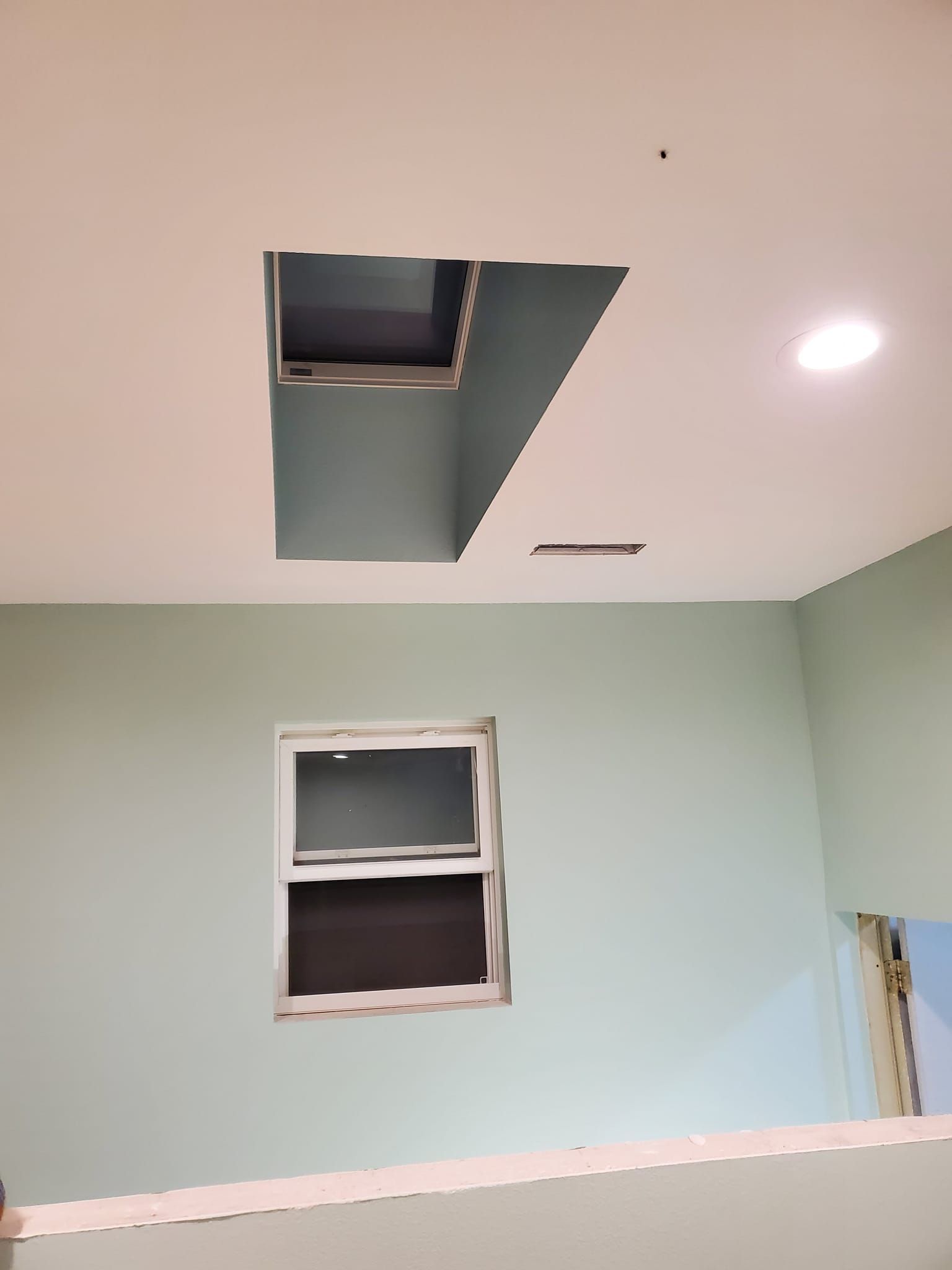 A hole in the ceiling with a window in it