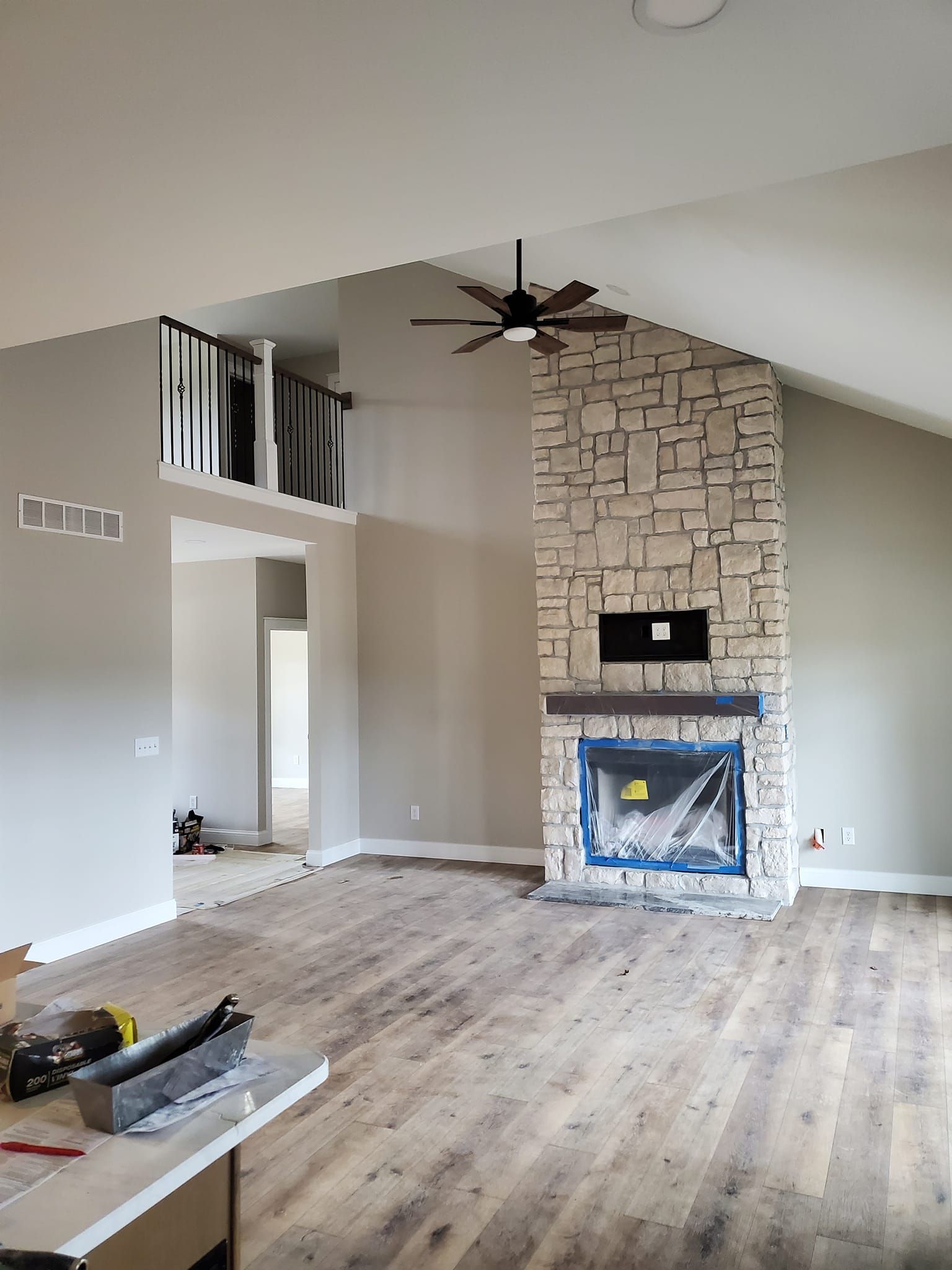 A living room with a fireplace and a ceiling fan.