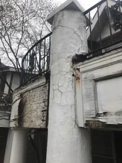 A black and white photo of a chimney on the side of a building.