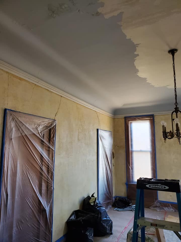 A room is being painted with a ladder in the foreground