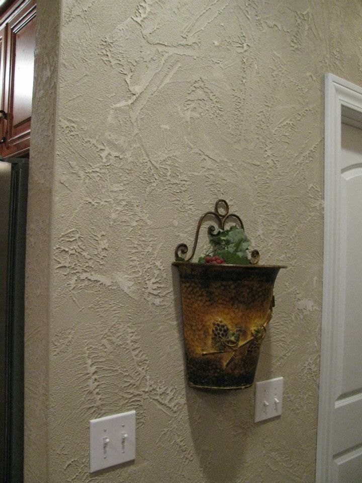 A vase is hanging on a wall next to a door.