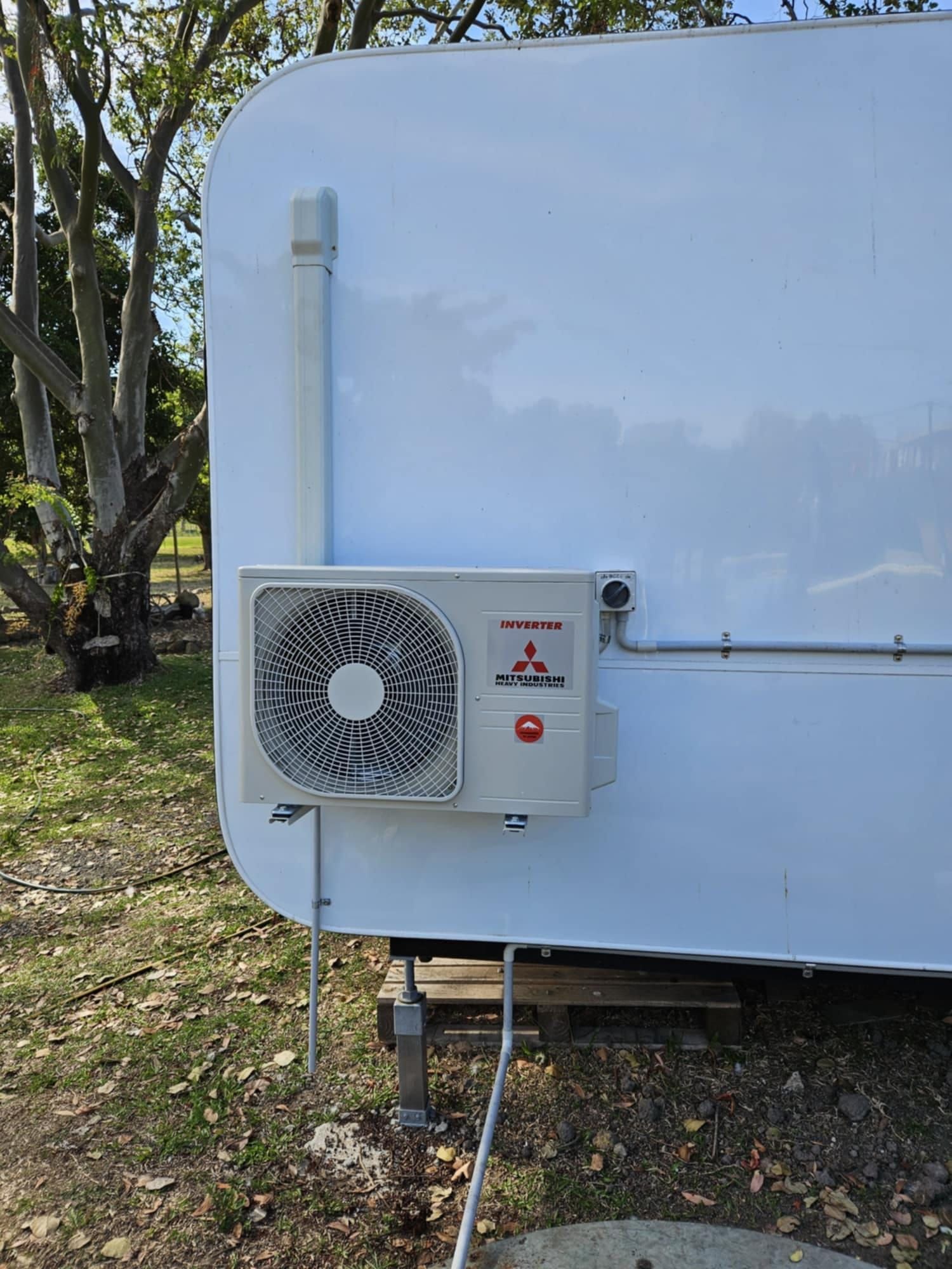 White Mitsubishi Air Conditioner Unit Mounted On A White Trailer Exterior, With Connected Tubing — Lit Energy in Seaforth, QLD