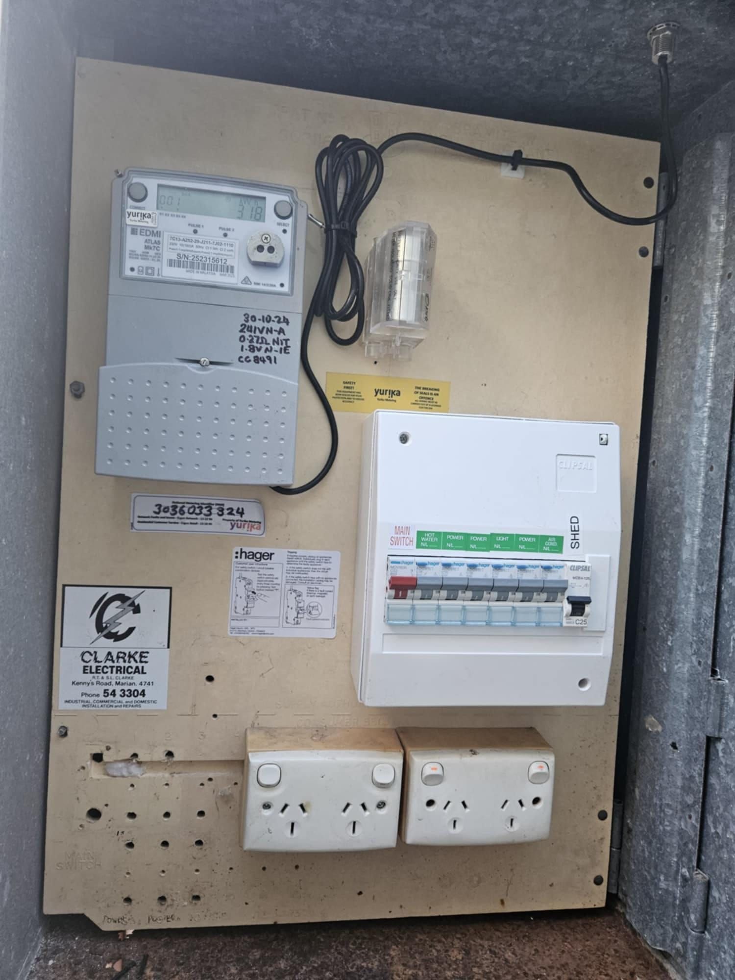 Person Using a Screwdriver to Work on Electrical Wiring Inside a Metal Panel — Lit Energy in Seaforth, QLD