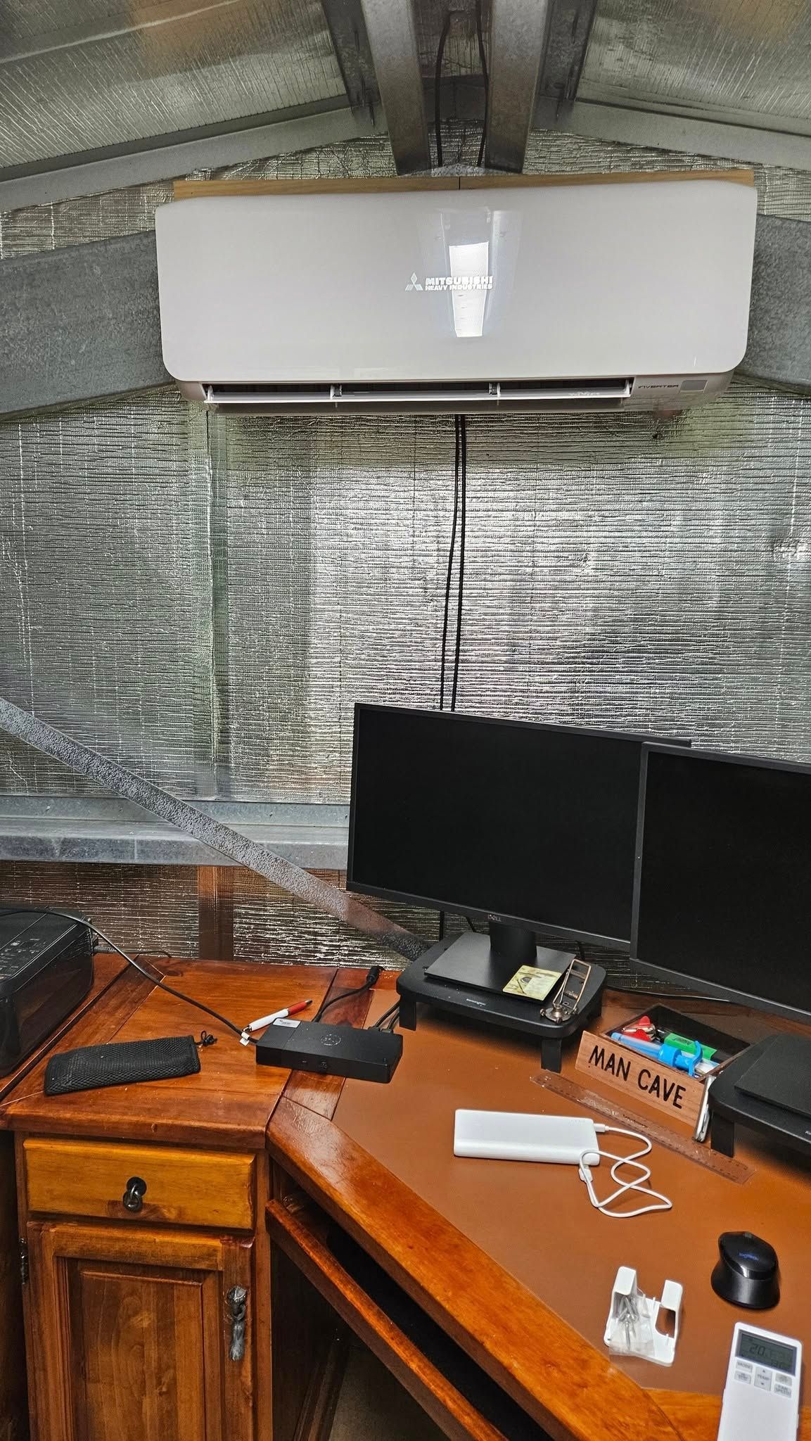 White Ac Unit Above Desk In A Home Office. Wood Desk With Equipment, Two Monitors And A Window With Blinds — Lit Energy in Bloomsbury, QLD